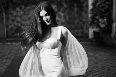 Dışarıda poz veren güzel genç gelinin siyah beyaz portresi. 