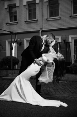 Güzel genç çift düğün günü sokakta siyah beyaz dans ediyor. 