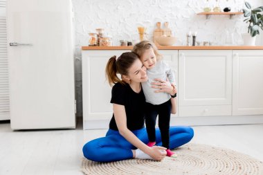 Kızı evde sarılırken mutlu bir anne. 