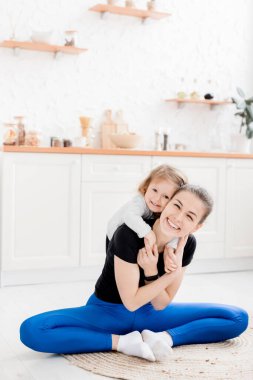 Mutlu anne kızıyla evde yerde eğleniyor.