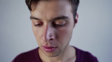 Pozitif genç adam kameraya gülümsüyor akıllı telefondan oyun oynuyor