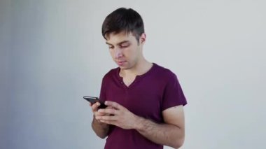 Süper heyecanlı erkek öğrenci. Beyaz adam kazanan teklifi kutluyor ya da akıllı telefondan ecommerce alışveriş teklifi alıyor. Heyecanlı erkek kazanan cep telefonuna bakarak başarıyı kutlayan bir uygulama kullanıyor, büyük testis gözlü.