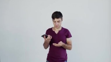 Süper heyecanlı erkek öğrenci. Beyaz adam kazanan teklifi kutluyor ya da akıllı telefondan ecommerce alışveriş teklifi alıyor. Heyecanlı erkek kazanan cep telefonuna bakarak başarıyı kutlayan bir uygulama kullanıyor, büyük testis gözlü..