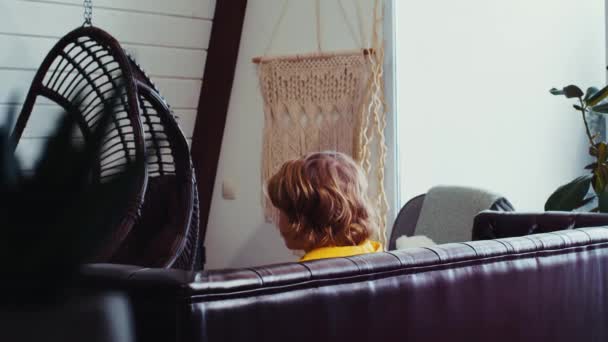 Back View Lone Teen Boy Sitting Sofa Playing Playstation Console — Stock Video