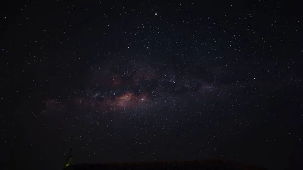 Gece ufkunda Samanyolu, gece yıldızlı gökyüzü, parlayan yıldızlar. Yıldız izleri yuvarlanıyor