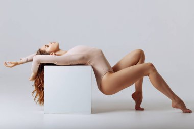 Stüdyoda bej bir elbise içinde güzel bir kız.