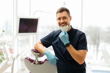 Klinikteki iş yerinin yanındaki genç dişçi.