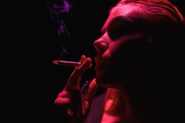 Neon ışıkta sigara içen kız