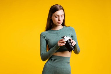 Sarı arka planda titreyen güzel bir spor kızı. Yüksek kalite fotoğraf