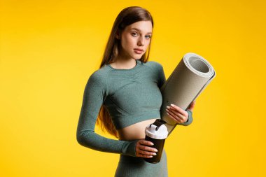 Sarı arka planda titreyen güzel bir spor kızı. Yüksek kalite fotoğraf