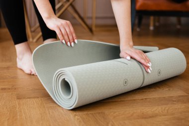 Girl rolling out a yoga mat. High quality photo