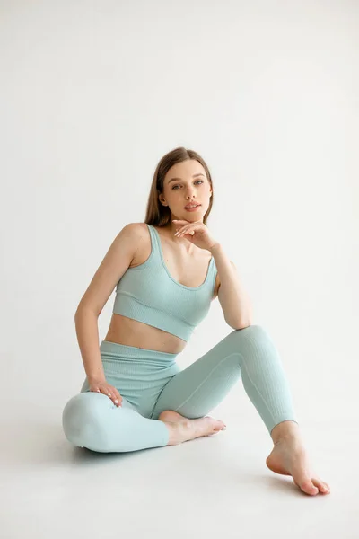 Beautiful Athletic Girl Blue Fitness Suit Sits White Background High — Stockfoto