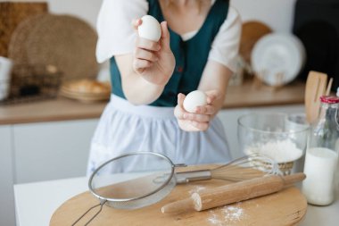 Girl confectioner holding chicken eggs in her hands. High quality photo