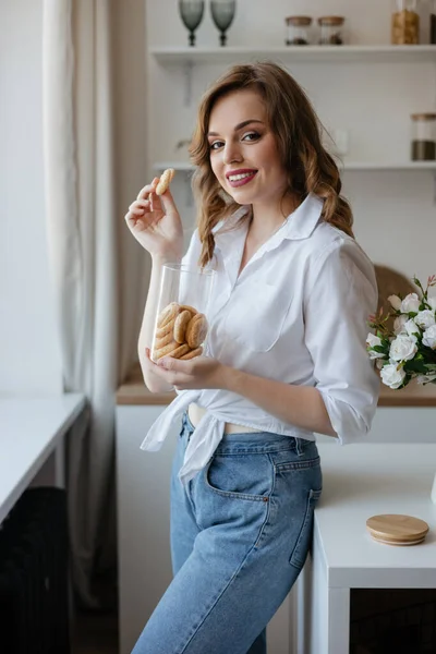 Pretty girl eating cookies in the kitchen. High quality photo