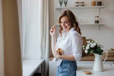 Güzel kız mutfakta kurabiye yiyor. Yüksek kalite fotoğraf