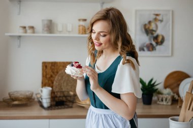 Housewife holding a cake in her hands while standing in the kitchen. High quality photo