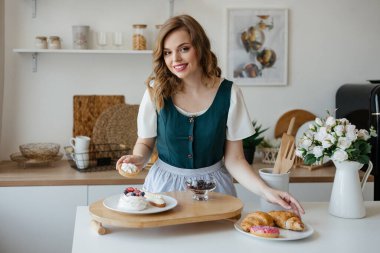 Girl shifts cakes on a dish in the kitchen. High quality photo