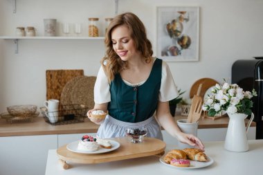 Girl shifts cakes on a dish in the kitchen. High quality photo