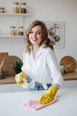 Housewife in yellow gloves wipes the kitchen table. High quality photo