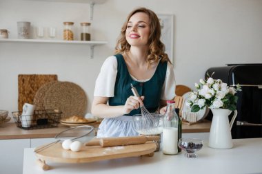 Pretty girl cooking in the kitchen. High quality photo