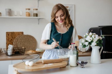 Pretty girl cooking in the kitchen. High quality photo