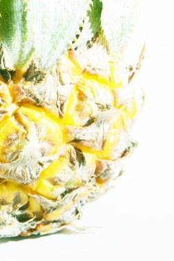 Olgunlaşmış ananas ve dilimler ve beyaz arka planda en üstte