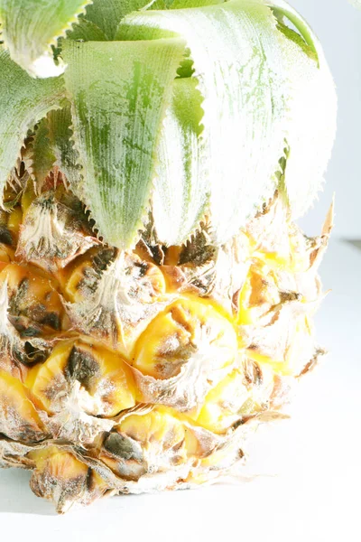 Olgunlaşmış ananas ve dilimler ve beyaz arka planda en üstte