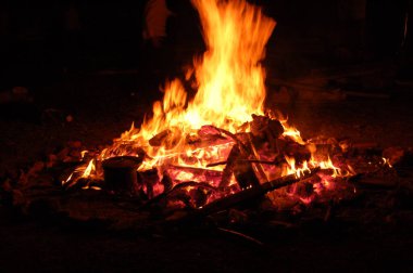 Büyük tahtaları olan şenlik ateşi, gecenin karanlığında. Gecikme Ömer için