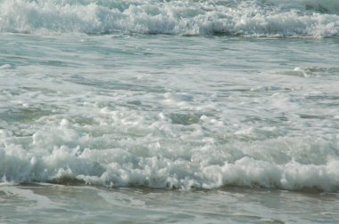 Deniz dalgaları ve baloncuklarla dolu fırtınalı bir yüzey arka plan ya da duvar kağıdı gibi.