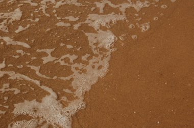 Denizin yüzeyi kumsalda, dalgalar arka plan olarak ya da duvar kağıdı olarak.