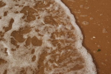 Denizin yüzeyi kumsalda, dalgalar arka plan olarak ya da duvar kağıdı olarak.