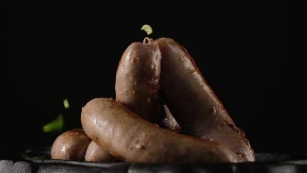 Greens fall on fried sausages — Stock Video