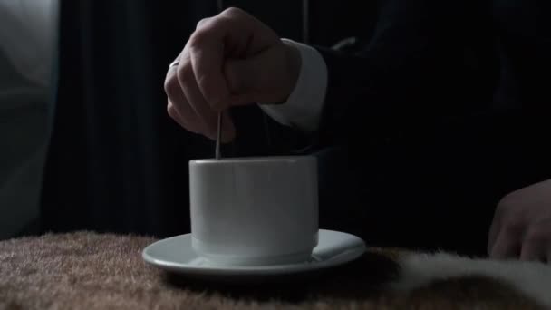 Man rör om en kopp kaffe står på bordet — Stockvideo