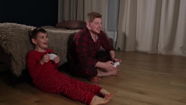 Vader concurreert met zoon in video game console — Stockvideo