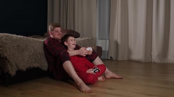 Активный папа играет с сыном в приставку для видеоигр — стоковое видео