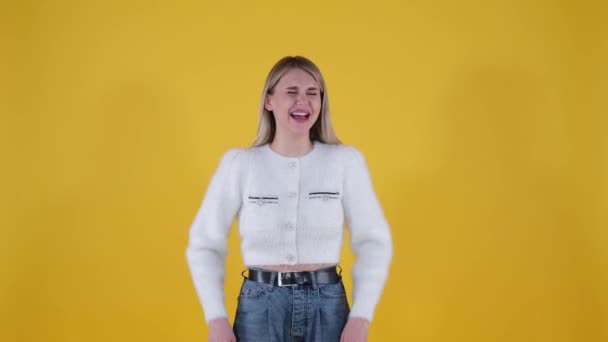 The girl laughs charmingly on a yellow background — Stock Video