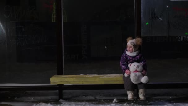 A lány egyedül vár a buszmegállóban a buszra. — Stock videók