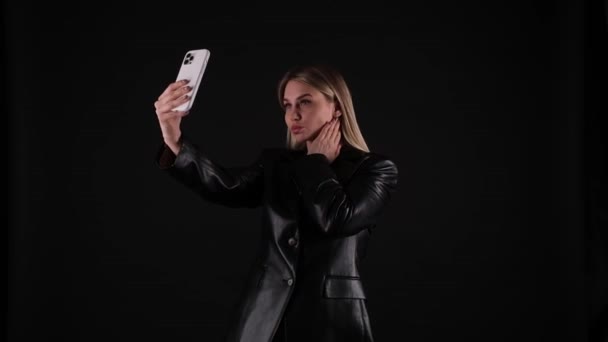 Blondine in schwarzer Jacke macht ein Selfie — Stockvideo