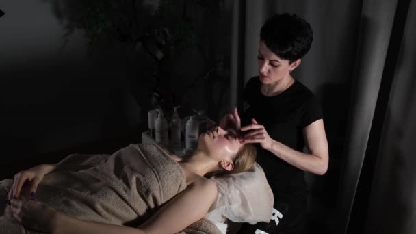 Massagista dando massagem facial para mulher loira — Vídeo de Stock