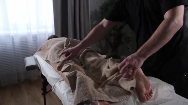 Massage professionnel des jambes masculines dans le salon — Video