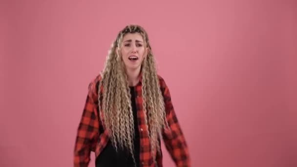 Blond op een roze achtergrond op de rand van hysterie — Stockvideo