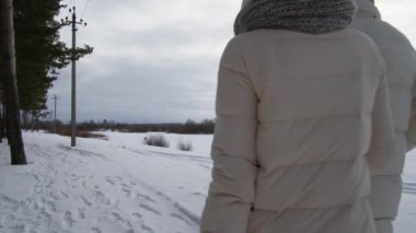 İki insan kış yolu boyunca yürür