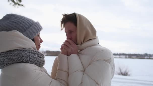 Chlapík zahřeje dívčí ruce v zimě — Stock video