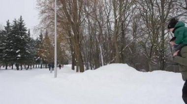 Omuzlarında çocuğu olan baba annesinden kaçıyor.