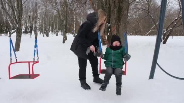 Nette Mutter legt Fäustlinge auf ihr Kind — Stockvideo