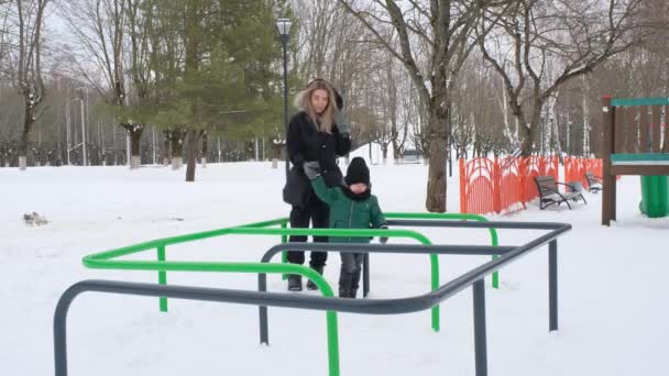 Filho com a mãe passar a cobra no parque infantil — Vídeo de Stock