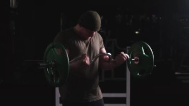 Dayanıklılık eğitimindeki seksi adam. Çelik kaslar. Terden bir parıltı. Atletik erkek figürü. Ağır demir çubuk.
