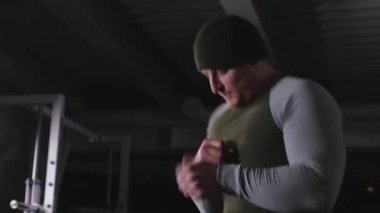 Eğitimden önce ellerin kaslarını ısıtıyor. Güç yüklemesi için eklemlerin hazırlanması. Spor salonunda güçlü bir adam..