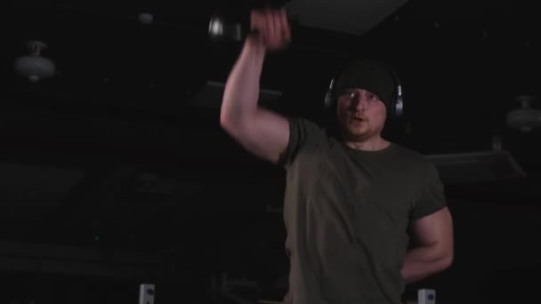 一个强壮的人接受音乐的训练 紧张的举重训练 那家伙抽动肌肉 — 图库视频影像