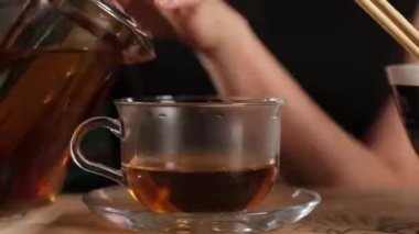 Kız fincana çay dolduruyor.